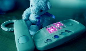 Teddy bear next to a phone - dial 988 for suicide prevention